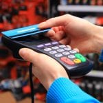 Hand of woman paying with contactless credit card, NFC technology