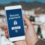 Man holding mobile phone. Secure payment notification in the screen.