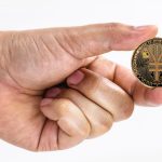 male hand holding e-RMB coin on isolated white background with space copy, china virtual money concept.